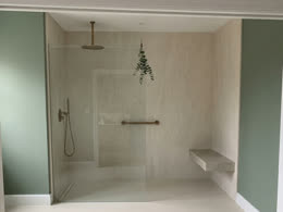 Beige walk-in shower with a built-in bench