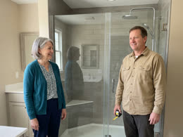 A homeowner and an installer beside the finished shower
