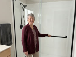 A homeowner beside the finished shower