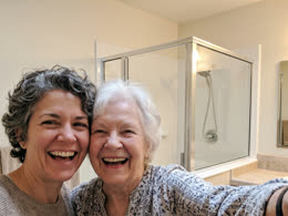 Two women in front of a finished glass shower