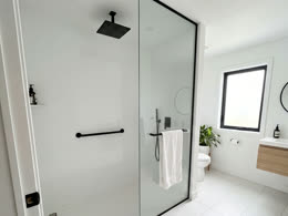 White walk-in shower with a glass panel